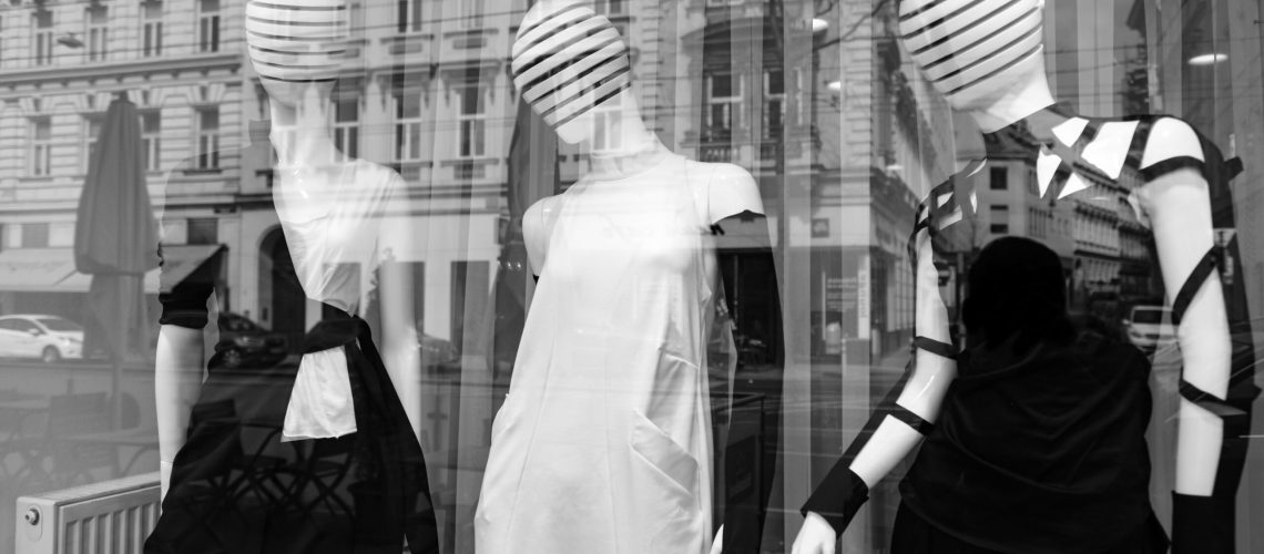 Mannequins in a display window with city reflections in black and white, Vienna, Austria.